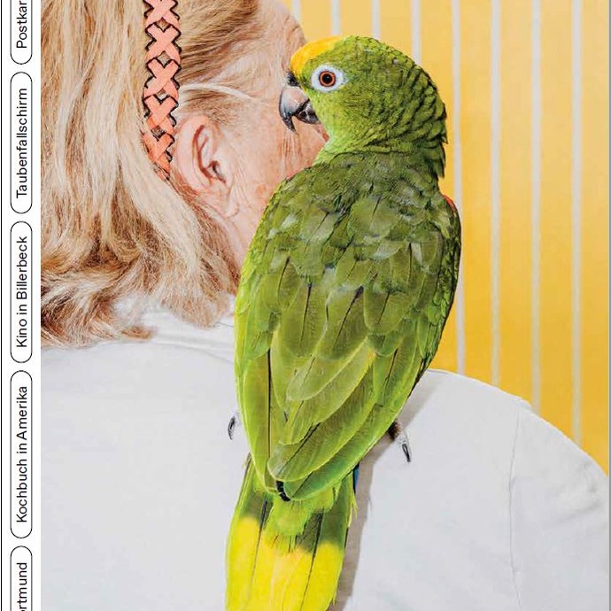 Magazincover Graugold - Ausgabe 2021. Frau von hinten mit Papagei auf der Schulter. (vergrößerte Bildansicht wird geöffnet)