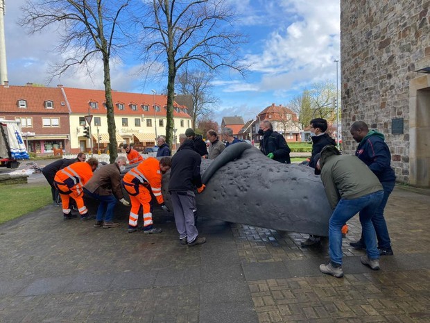 Anlieferung der Walskulptur - Ehrenamtliche und Hauptamtliche tragen den Wal gemeinsam in das Ausstellungsgebäude