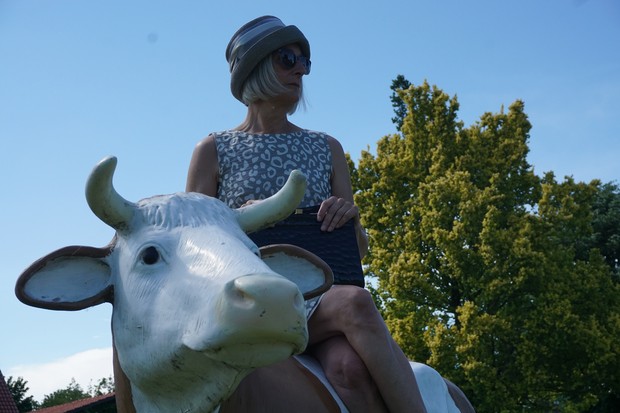 Birgit Aßhoff posiert auf einer Kunst-Kuh