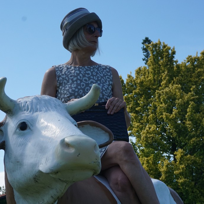 Birgit Aßhoff posiert auf einer Kunst-Kuh (vergrößerte Bildansicht wird geöffnet)