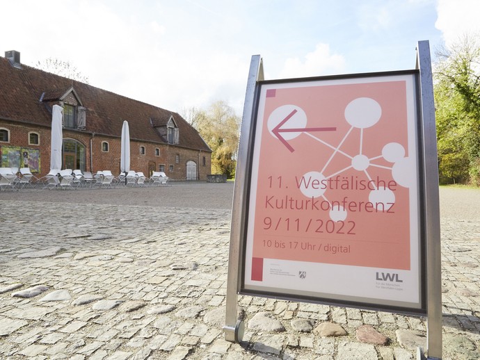 11. Westfälische Kulturkonferenz - Plakat mit Kulturgut Haus Nottbeck in Oelde im Hintergrund (vergrößerte Bildansicht wird geöffnet)