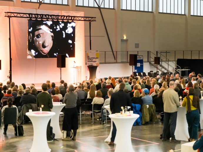 Konferenzteilnehmer:innen beim Betrachten des künstlerischen Impulses von Dr. Nesrin Tanç (vergrößerte Bildansicht wird geöffnet)