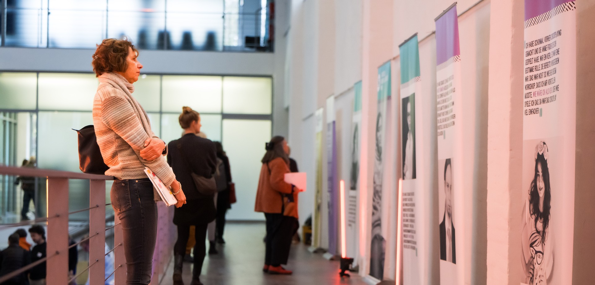 Eine Person betrachtet die Roll-Ups der Cross-Dressing Ausstellung.