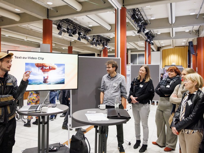 Ki-Werkstatt-Referent Sebastian Gröne mit Konfernenzteilnehmer:innen (vergrößerte Bildansicht wird geöffnet)