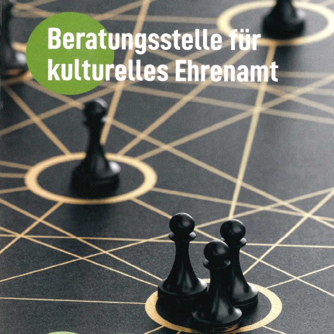 Spielfiguren auf einem Spielfeld mit Text ("Beratungsstelle für kulturelles Ehrenamt") (vergrößerte Bildansicht wird geöffnet)