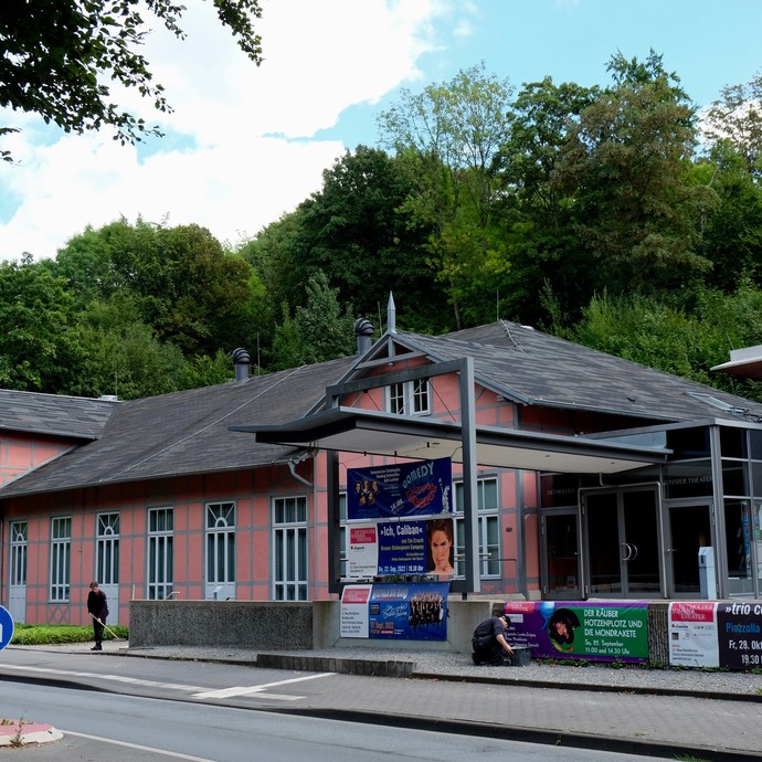 Gebäude Außenansicht mit Plakatwerbung für Theaterstücke (vergrößerte Bildansicht wird geöffnet)